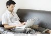 stock-photo-a-young-professional-man-working-from-home-relaxed-on-the-sofa-17839483.jpg